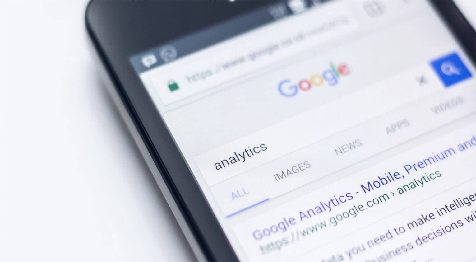 Close-up of a smartphone screen displaying a Google search results page for the term "analytics."