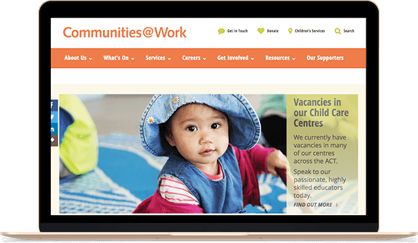 Website homepage on a laptop screen showing a toddler in a hat and a childcare vacancy announcement.