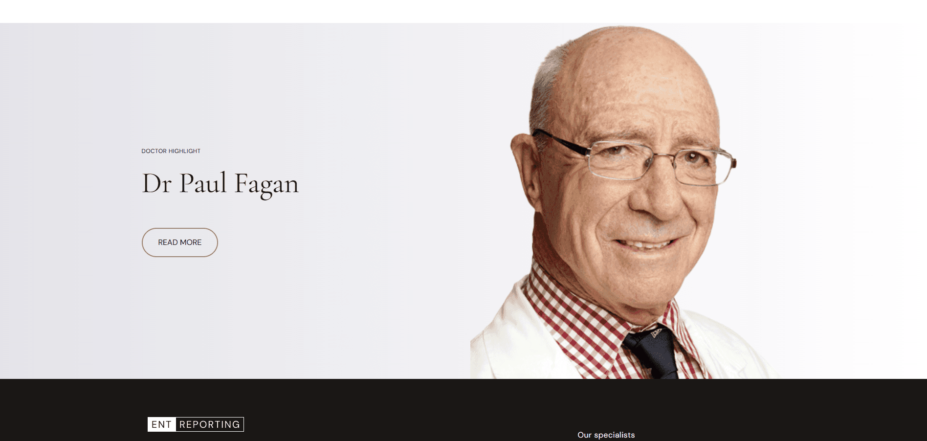 Smiling elderly doctor wearing glasses, white coat, checkered shirt, and dark tie on a light background.